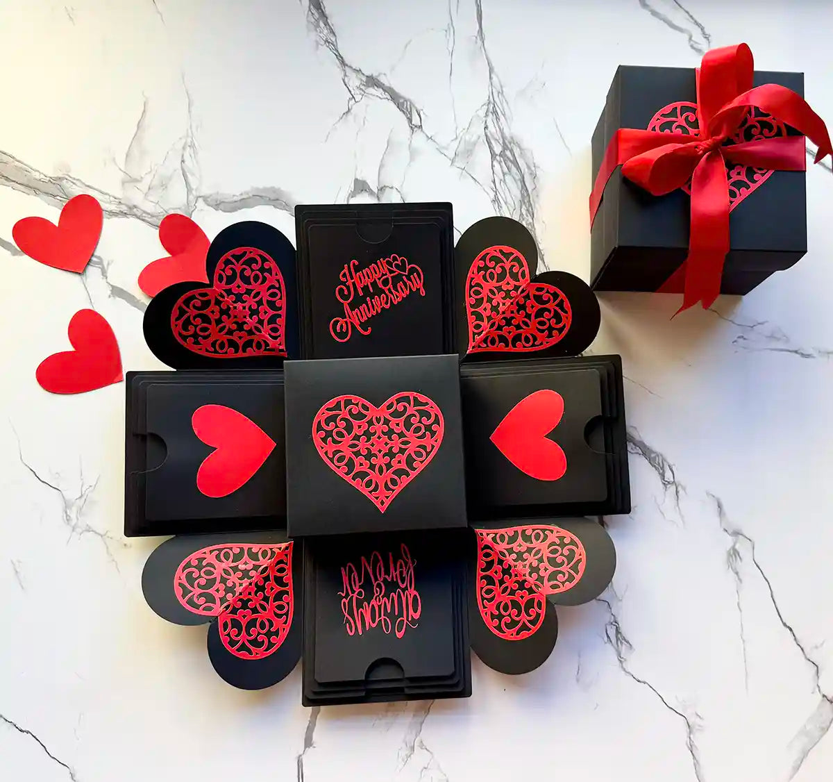 Red and black anniversary explosion gift box unopened, angled shot with ribboned lid