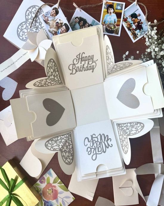 Explosion gift box for birthday in white color with photo strings and flowers.