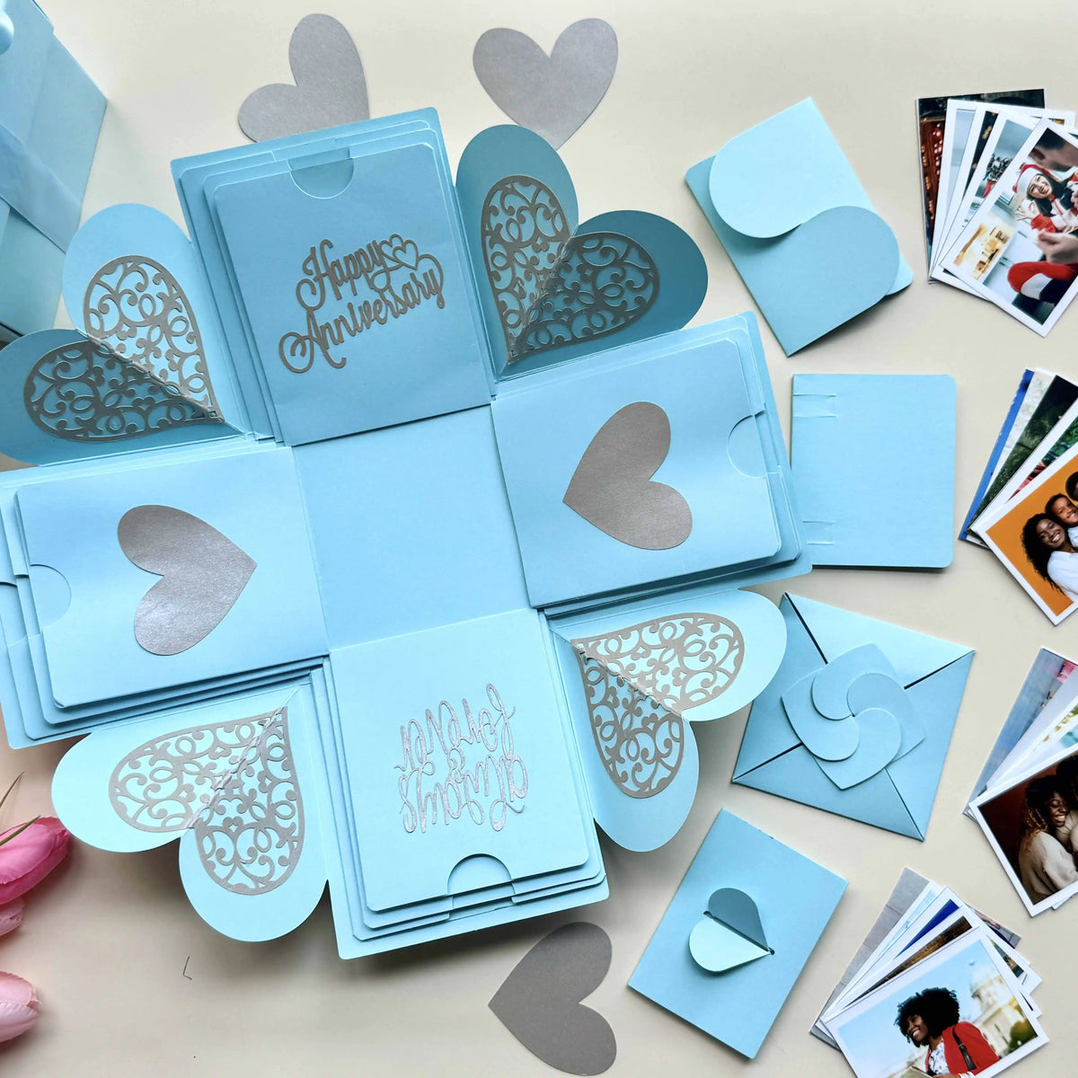 Flat-lay view of blue explosion gift box with pull-out albums and photo pockets
