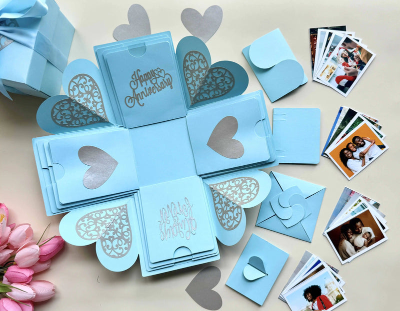Flat-lay view of blue explosion gift box with pull-out albums and photo pockets