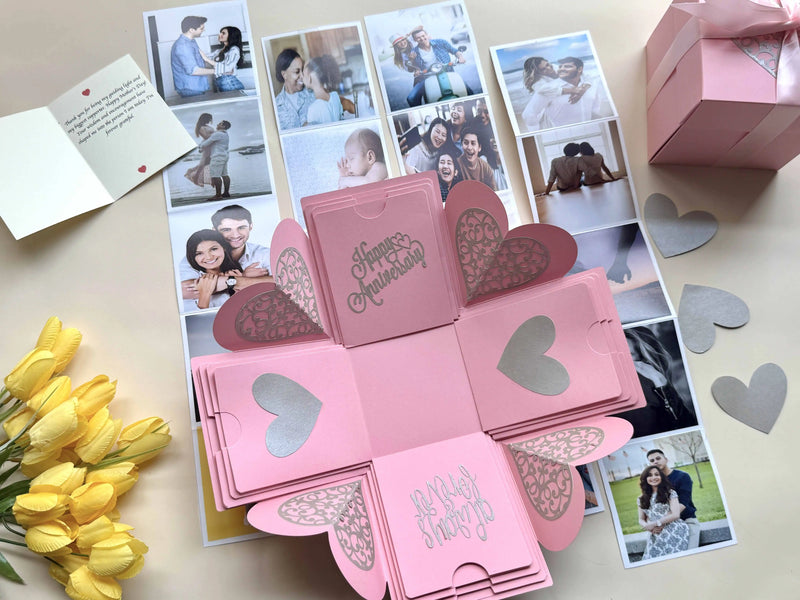 Pink anniversary explosion gift box with origami photo pockets, top-down view