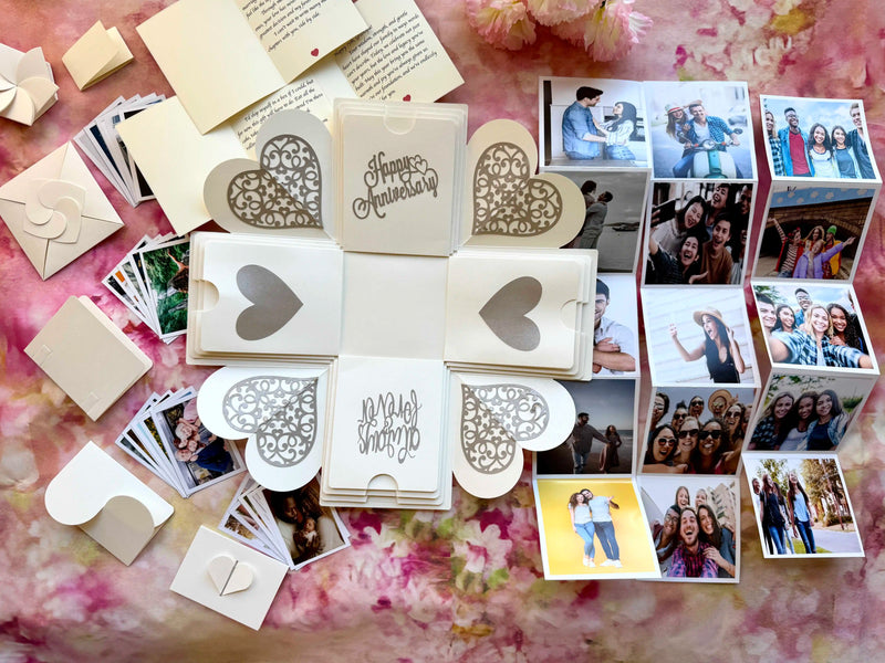 White anniversary explosion gift box opened flat, showing photos and message cards