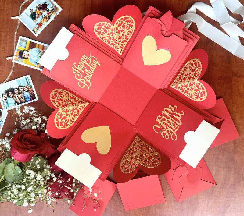 Red birthday explosion box highlighting a message layer, customized pull-out photo albums, and personalized wallet photos.