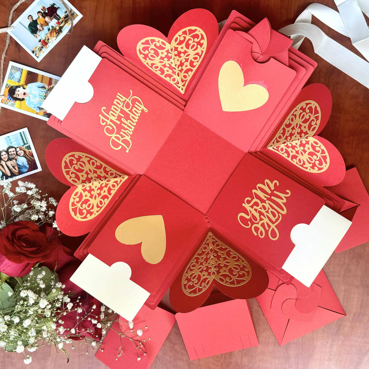 Red birthday explosion gift box opened with personalized photo inserts visible