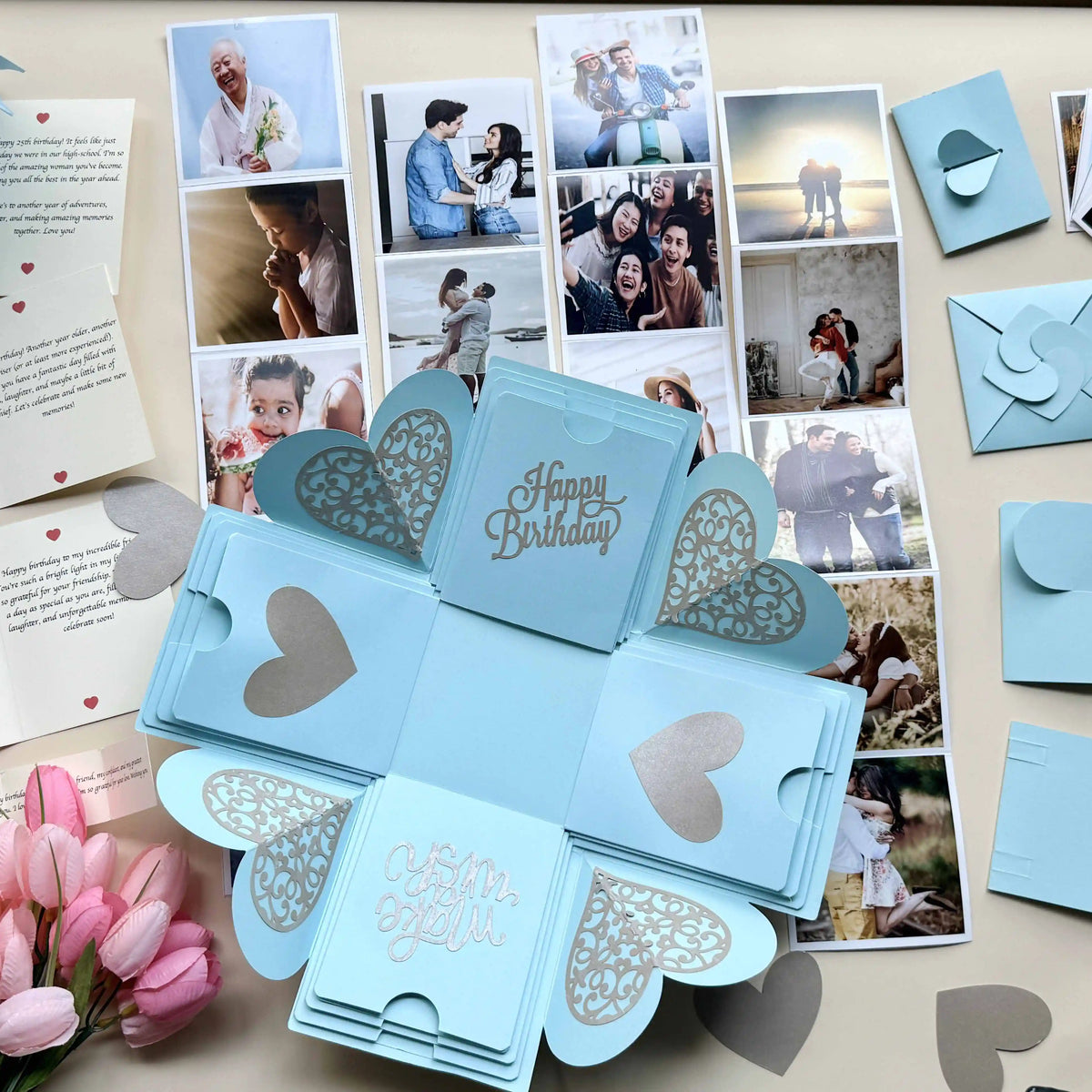 Flat-lay of blue birthday explosion gift box with photos and message layers