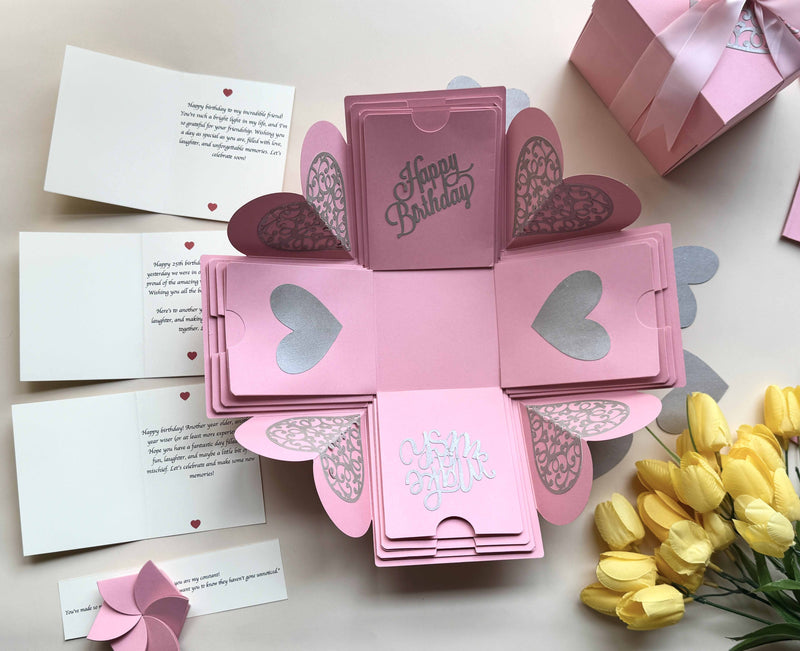 Explosion gift box for birthday customized with messages, texts and wishes. Gift box decorated with matching ribbons. Product photo with contents displayed. 