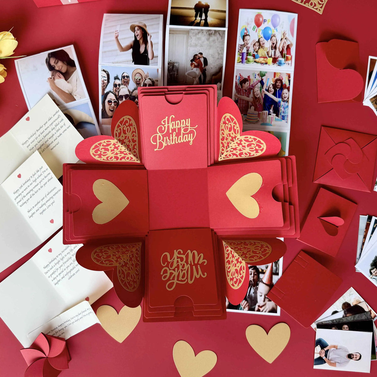 Red birthday explosion gift box fully opened showing photos, messages, and inserts