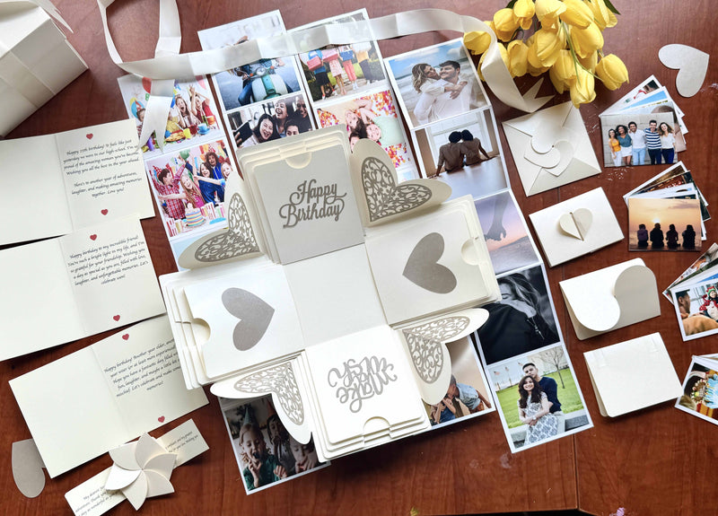 Explosion gift box for birthdays with customized photos, albums, messages and texts. Flat-lay photo decorated with flowers, ribbon and hearts.