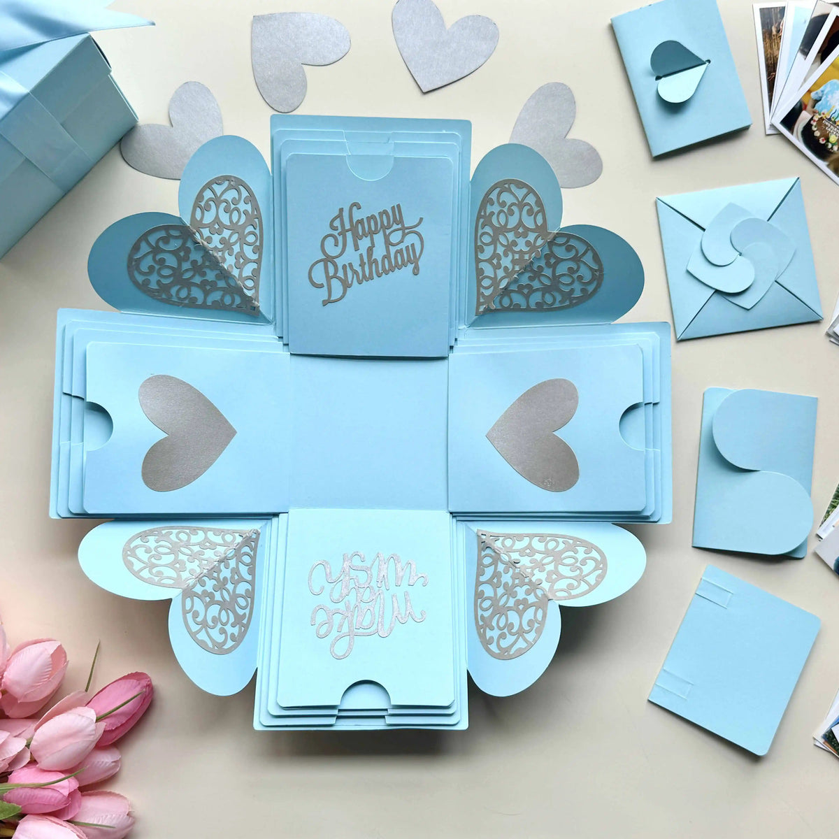 Close-up detail of blue birthday explosion gift box with customized polaroid photos
