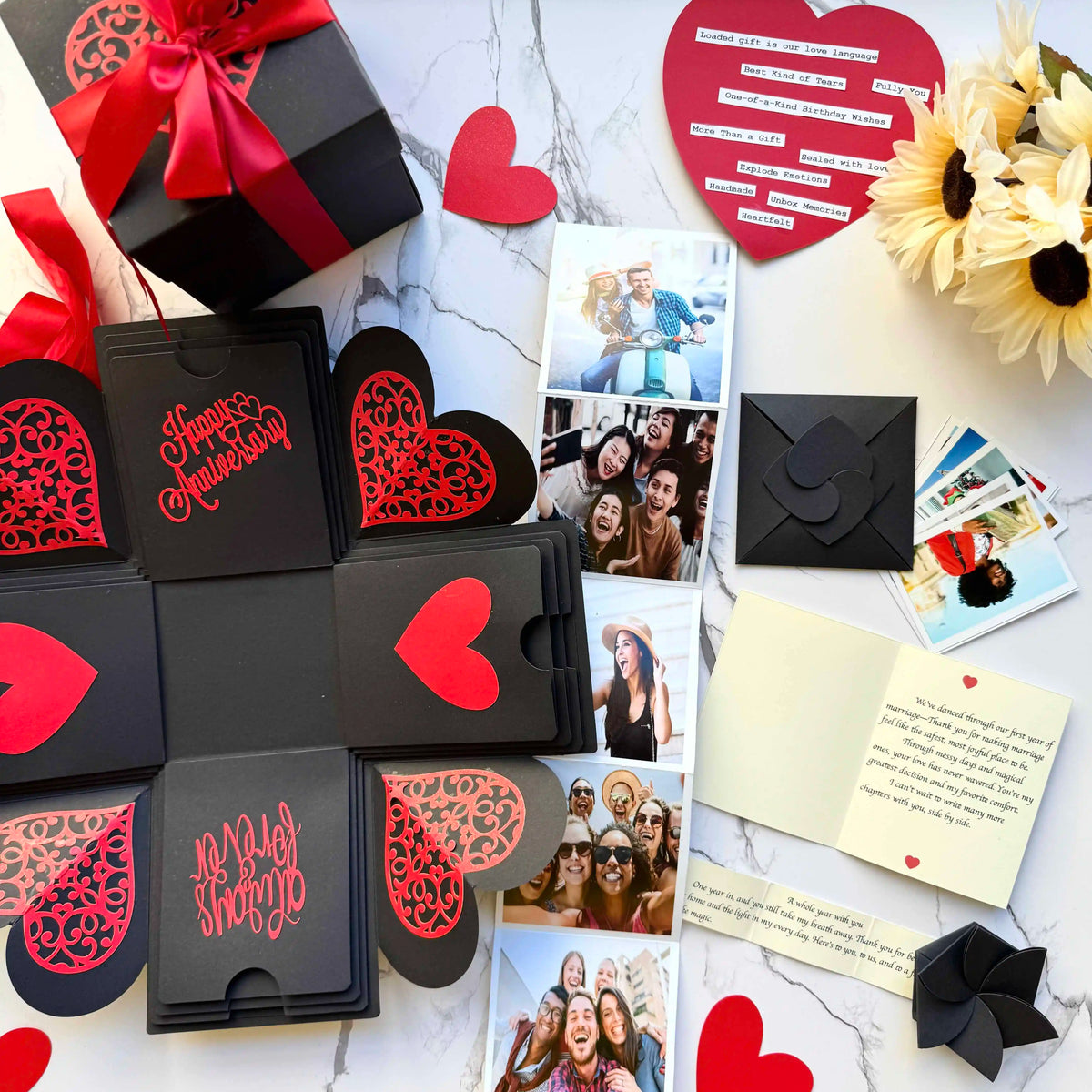 Red and black anniversary explosion gift box opened flat, showing photos and message cards