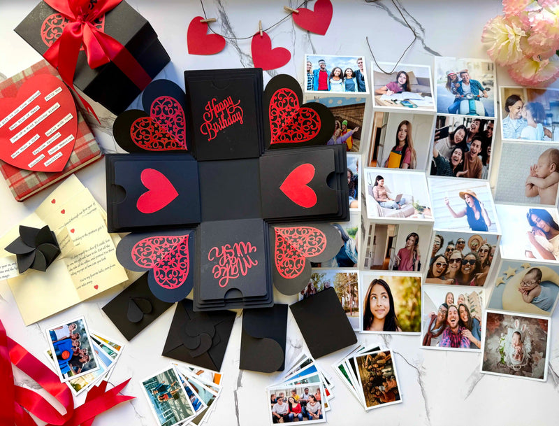 Close-up detail of black red birthday explosion gift box with custom photos and messages. All the contents spread across.
