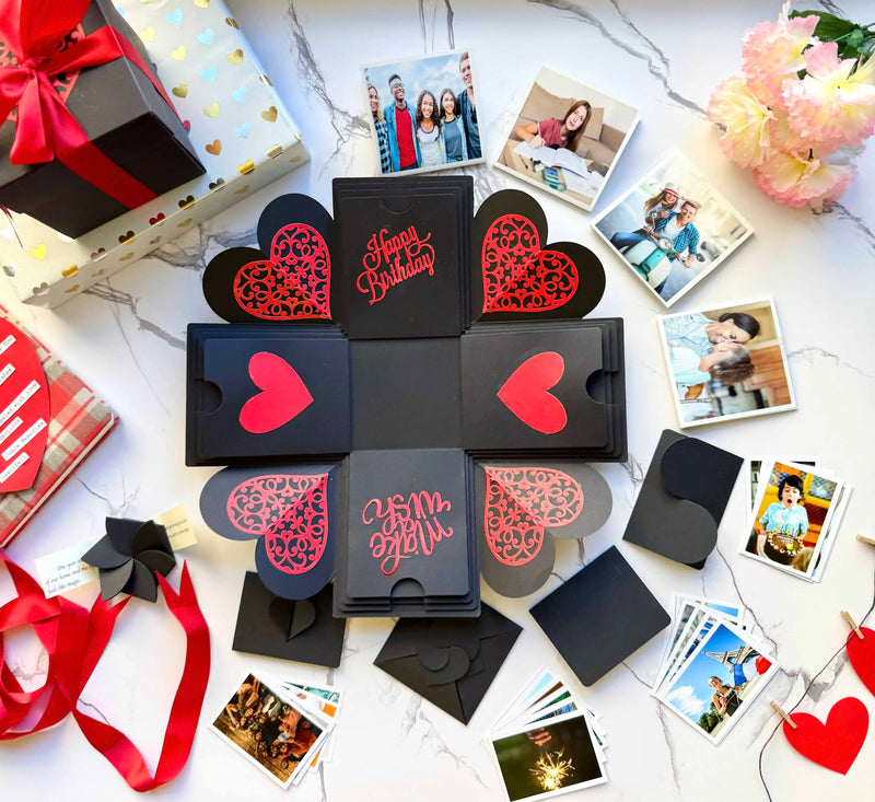 Flat-lay view of black and red explosion gift box with pull-out albums and photo pockets