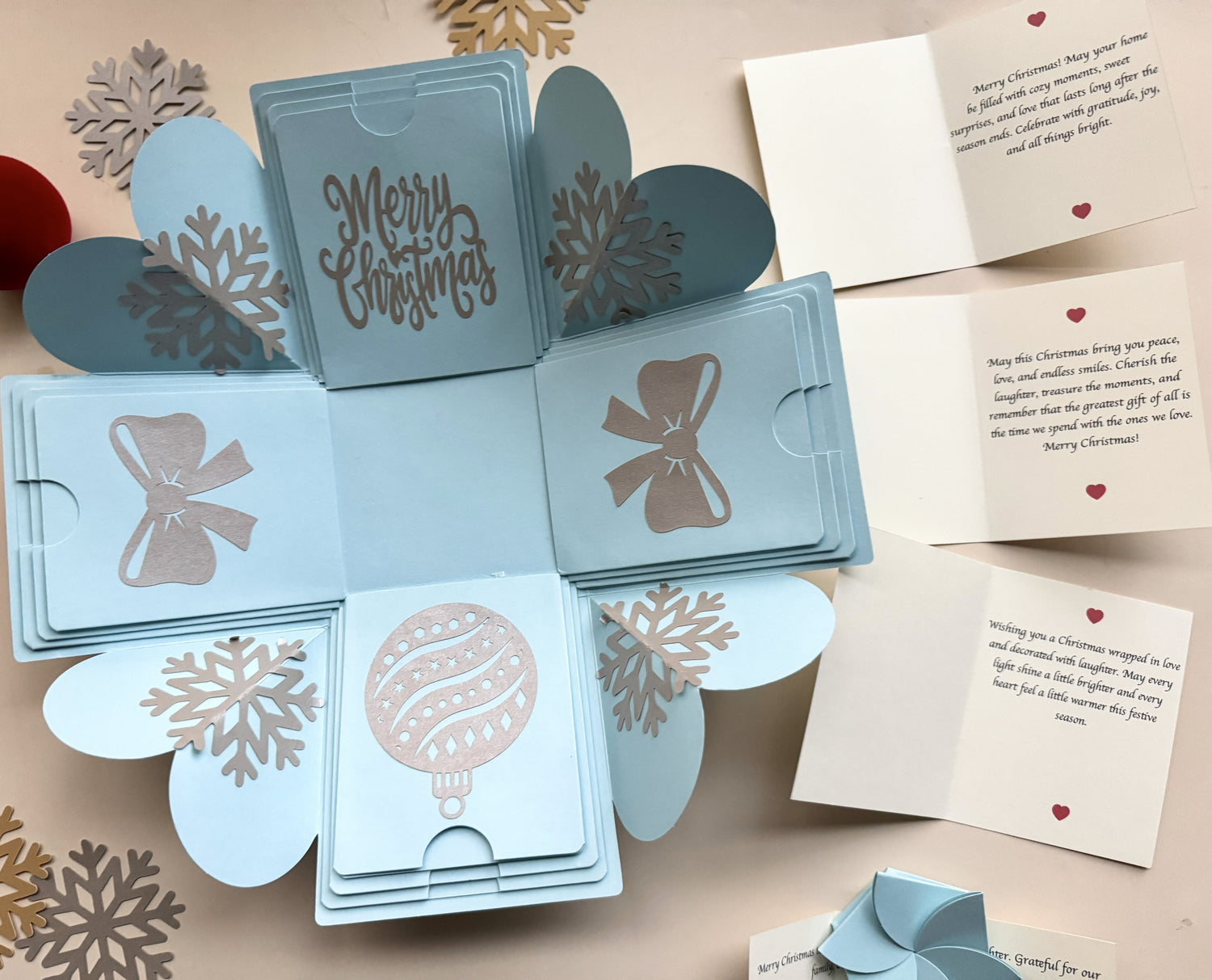 Top-view blue Christmas explosion gift box displaying extended pull-out photo albums.