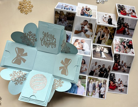 Flat lay of blue Christmas explosion gift box opened with contents spread around it.