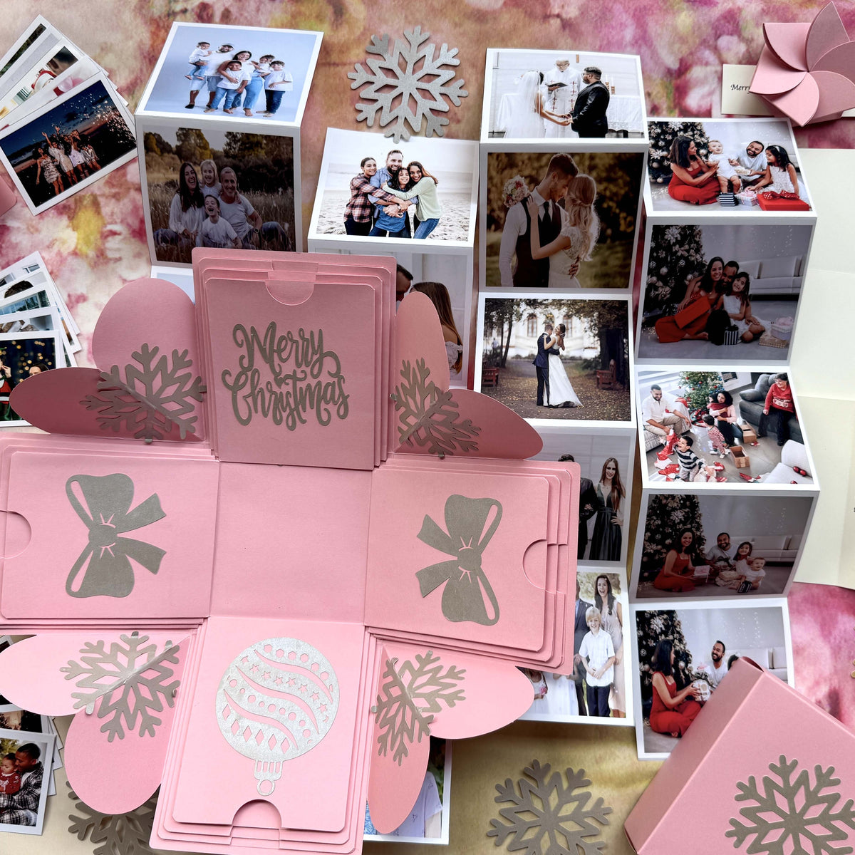Top-view pink Christmas explosion gift box showing extended pull-out photo albums.