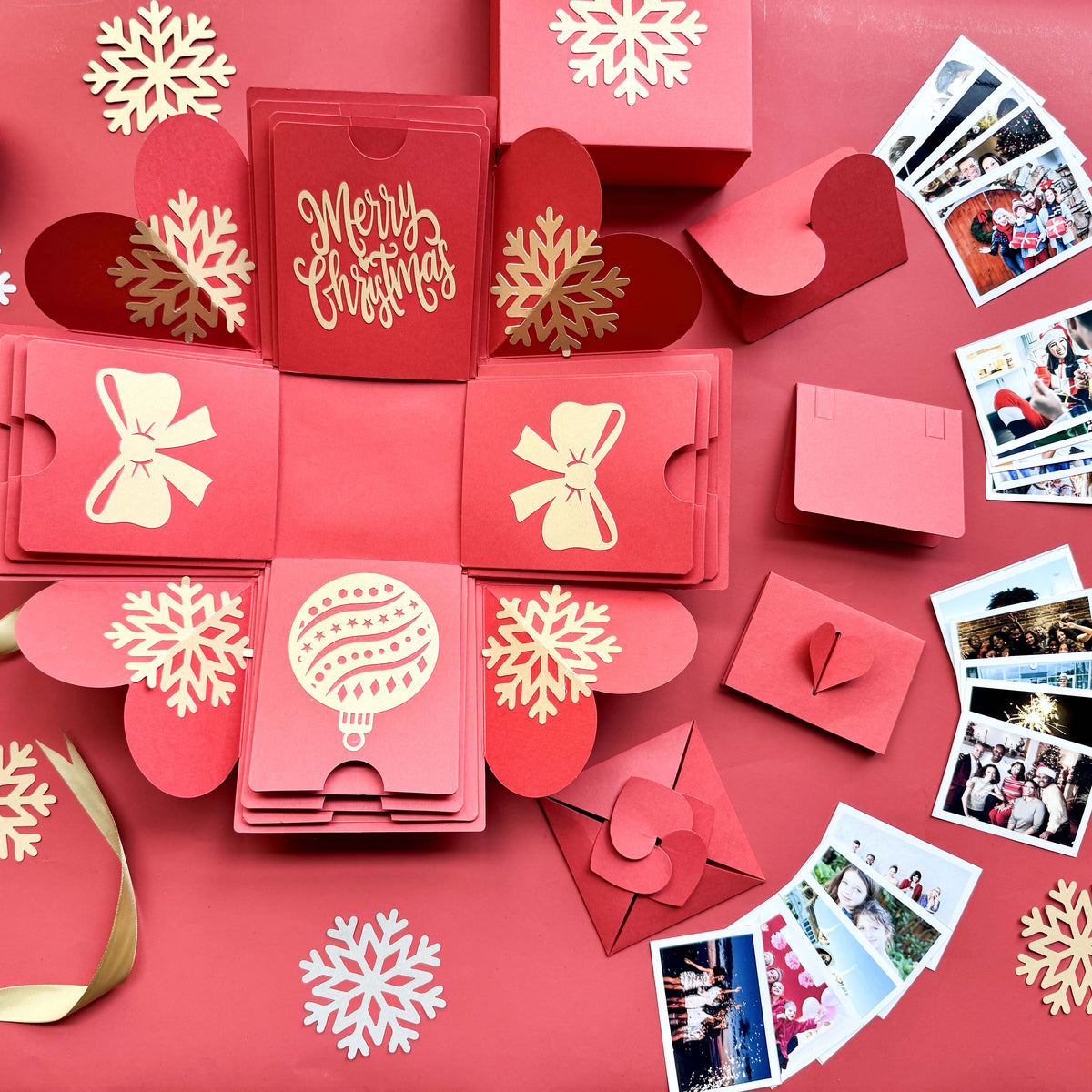 Open red Christmas explosion gift box displaying layered photos and festive design.