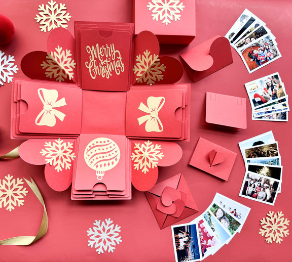 Open red Christmas explosion gift box displaying layered photos and festive design.