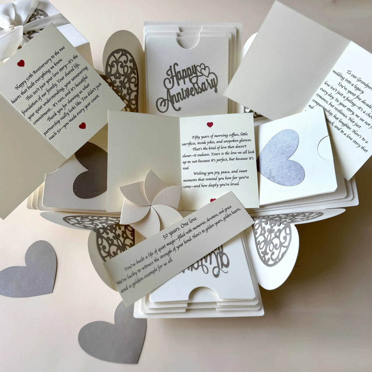 Flat-lay of white explosion gift box with pull-out albums and photo pockets