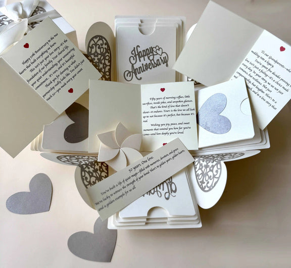 Flat-lay of white explosion gift box with pull-out albums and photo pockets