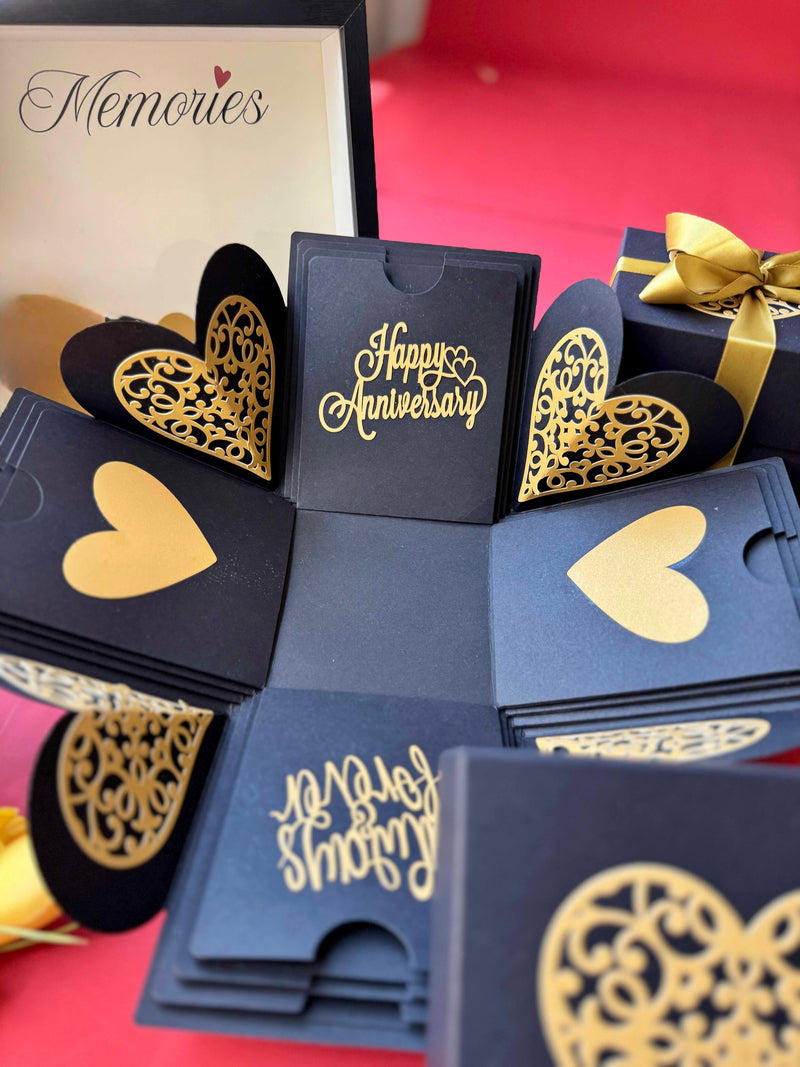 Fully opened black and gold explosion box with wrapped golden ribbon