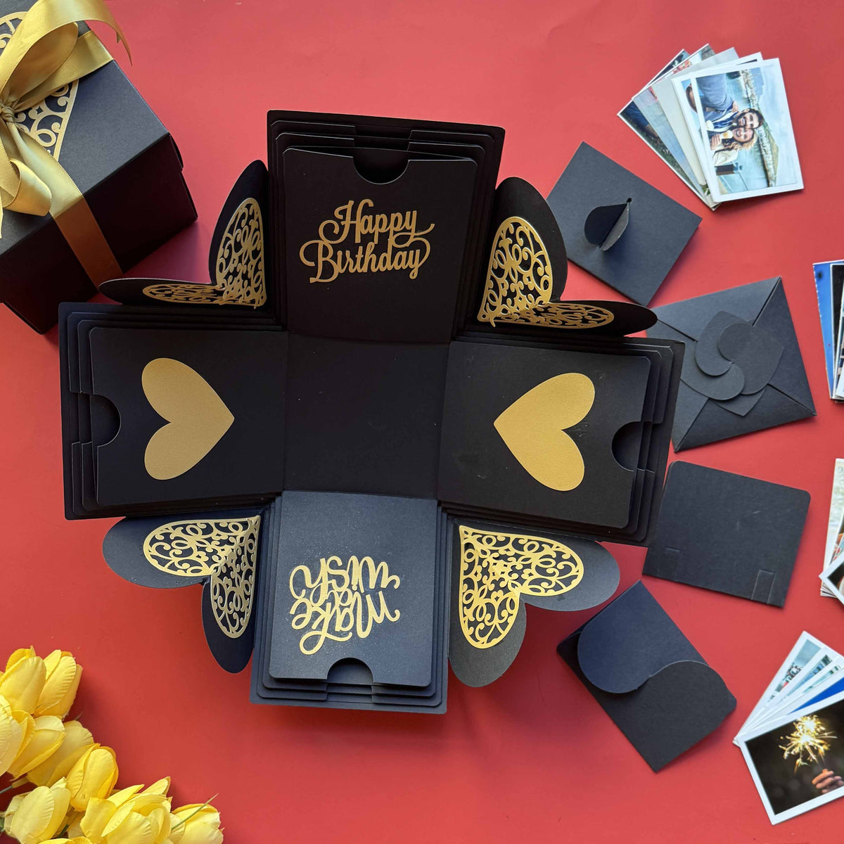 Black and gold explosion box with wallet-size photo prints—perfect for sharing birthday memories