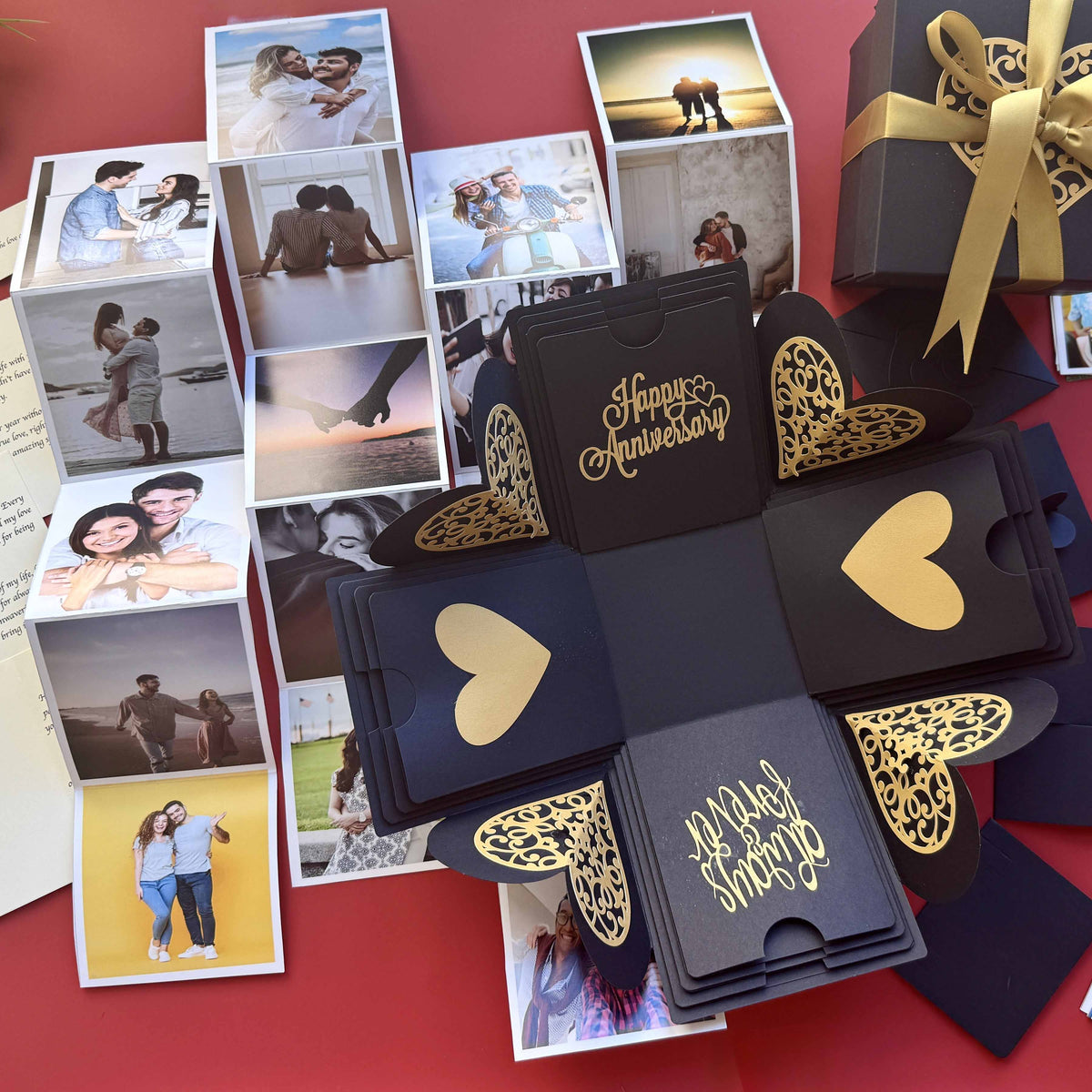 Black and gold explosion gift box with pull-out photo albums revealing couple memories