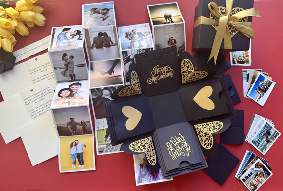 Black and gold explosion gift box with pull-out photo albums revealing couple memories