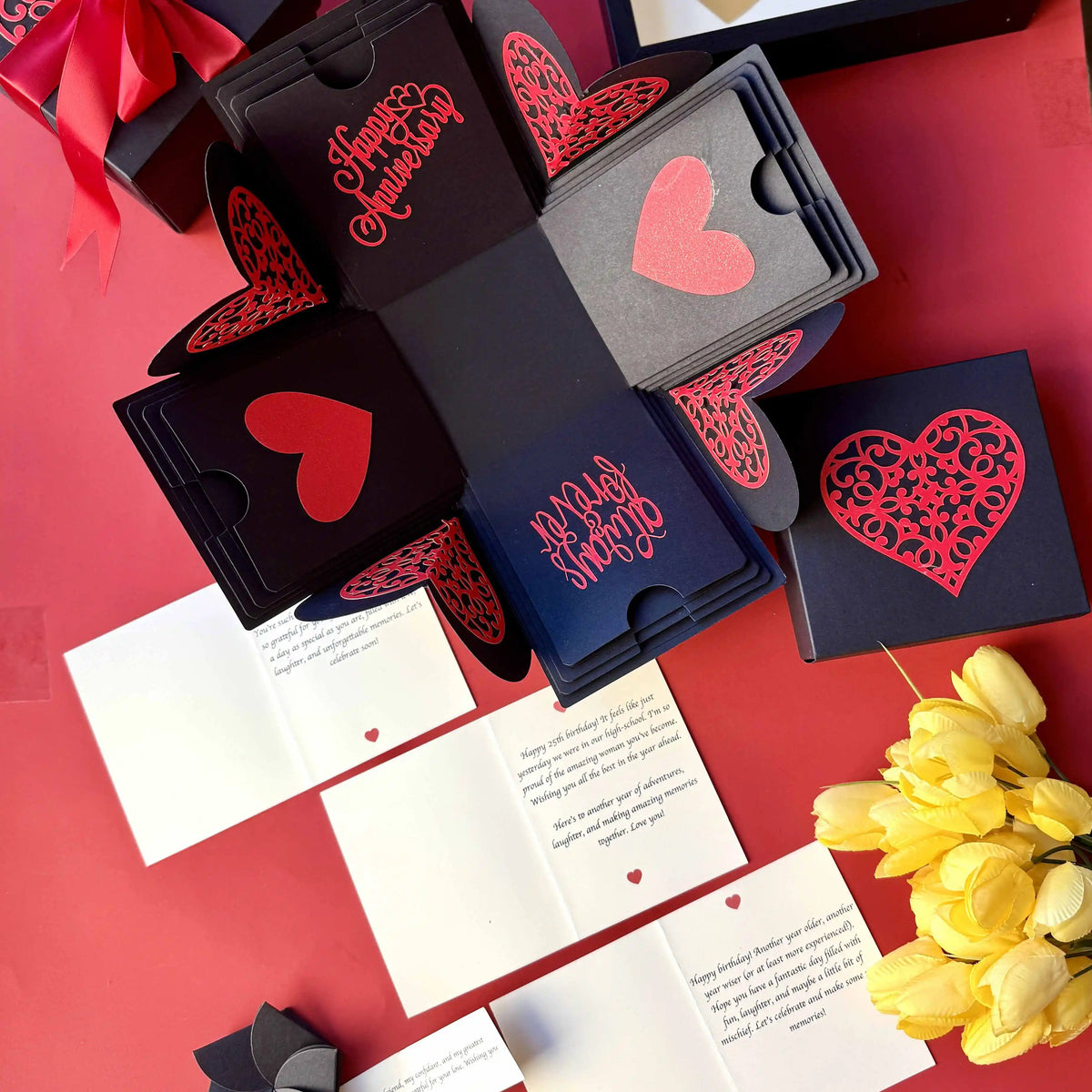 Flat-lay of red and black explosion gift box with pull-out albums and photo pockets