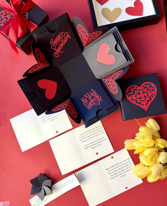 Flat-lay of red and black explosion gift box with pull-out albums and photo pockets