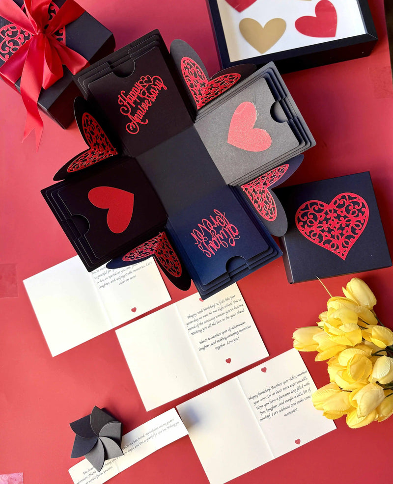 Flat-lay of red and black explosion gift box with pull-out albums and photo pockets