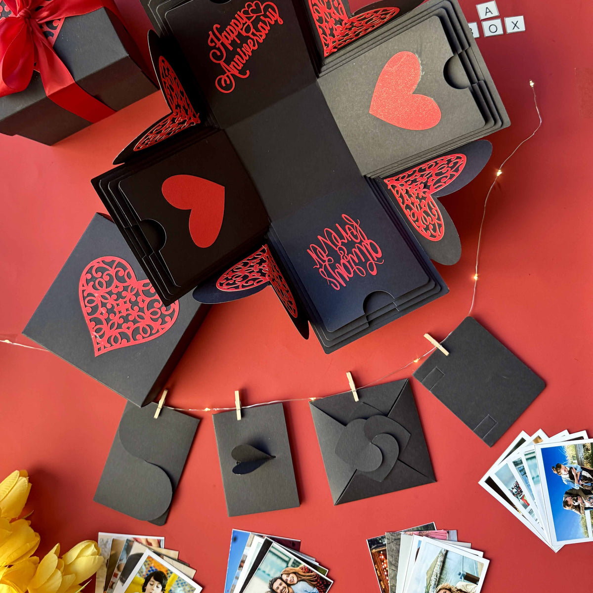 Black and red explosion box featuring wallet-size photo prints—ideal for celebrating shared memories