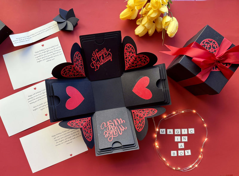 Open Black & Red birthday explosion box showing layers of photos, messages, and birthday decorations