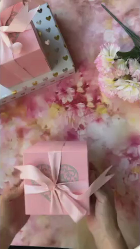 Product demo video of Pink anniversary explosion gift box opened flat, showing photos and message cards